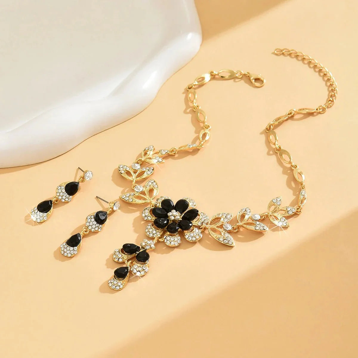 https://cdn.shopify.com/s/files/1/0820/4999/0943/files/floral-black-and-gold-diamond-necklace-and-earring-set-258782.webp?v=1718191087