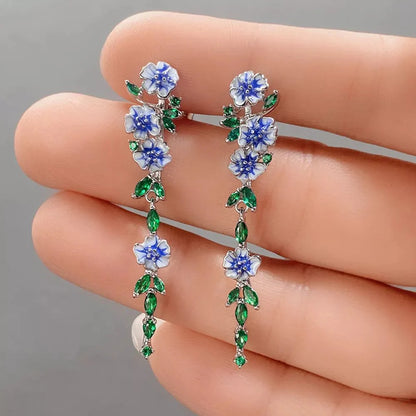 https://cdn.shopify.com/s/files/1/0820/4999/0943/files/glossy-blue-floral-dangling-earrings-120307.webp?v=1712446270