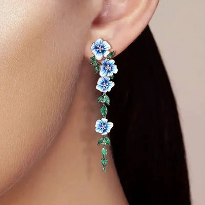 https://cdn.shopify.com/s/files/1/0820/4999/0943/files/glossy-blue-floral-dangling-earrings-666709.webp?v=1712446270