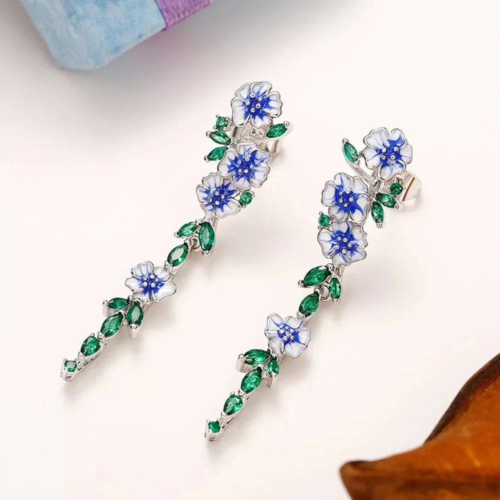 https://cdn.shopify.com/s/files/1/0820/4999/0943/files/glossy-blue-floral-dangling-earrings-790662.webp?v=1712446270