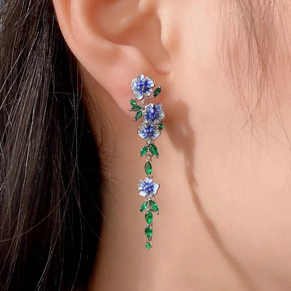 https://cdn.shopify.com/s/files/1/0820/4999/0943/files/glossy-blue-floral-dangling-earrings-932495.webp?v=1762198002