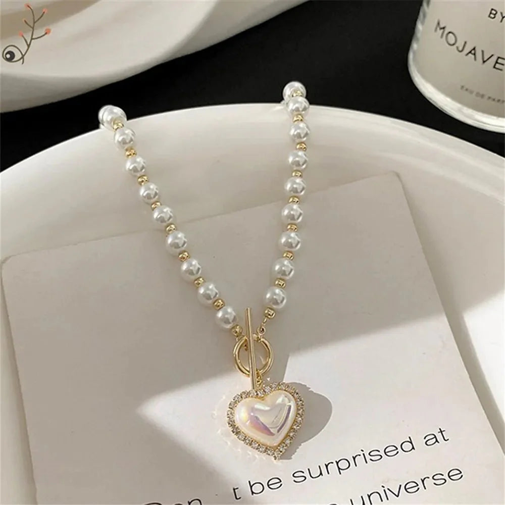 https://cdn.shopify.com/s/files/1/0820/4999/0943/files/pearl-heart-clasp-choker-necklace-251812.webp?v=1712446212
