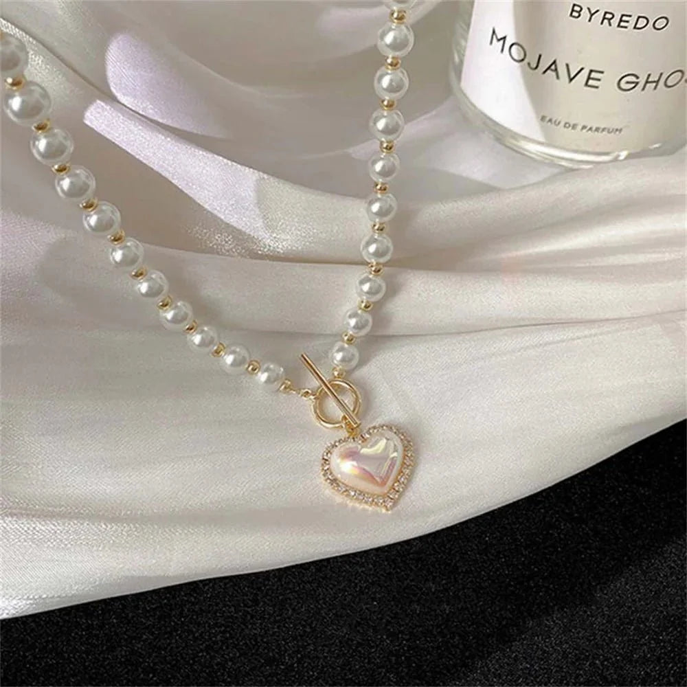 https://cdn.shopify.com/s/files/1/0820/4999/0943/files/pearl-heart-clasp-choker-necklace-258596.webp?v=1712446211
