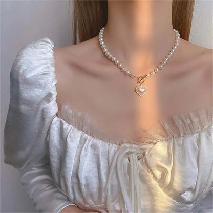 https://cdn.shopify.com/s/files/1/0820/4999/0943/files/pearl-heart-clasp-choker-necklace-590069.webp?v=1712446211