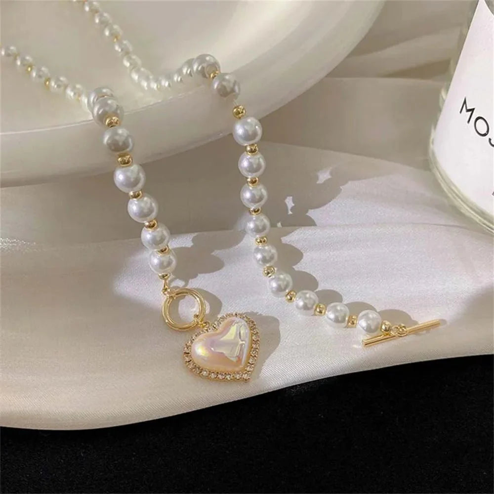 https://cdn.shopify.com/s/files/1/0820/4999/0943/files/pearl-heart-clasp-choker-necklace-618704.webp?v=1712446211