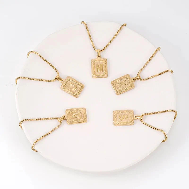 https://cdn.shopify.com/s/files/1/0820/4999/0943/files/textured-rectangle-letter-initial-necklace-162088.webp?v=1724157553