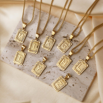 https://cdn.shopify.com/s/files/1/0820/4999/0943/files/textured-rectangle-letter-initial-necklace-945919.jpg?v=1724157553
